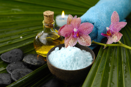 spa supplies with salt in bowl ,stones, candle, blue towel