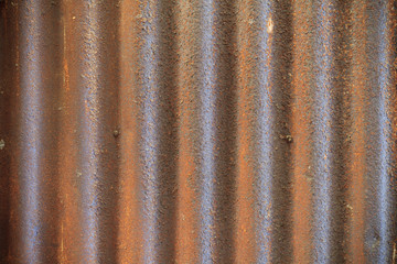 Rusty old corrugated iron fence close up