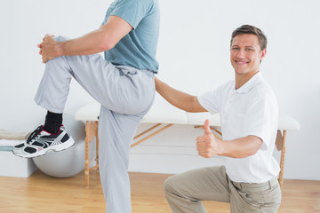 Obraz premium Therapist massaging mans lower back while gesturing thumbs up