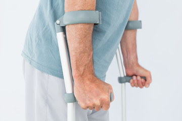 Close-up mid section of a man with crutches