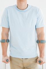 Close-up mid section of a man with crutches