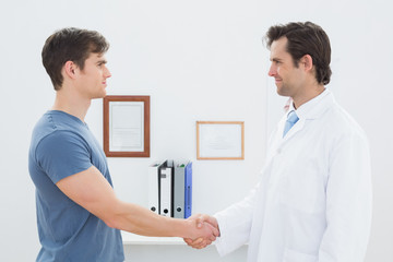 Fototapeta premium Doctor and patient shaking hands in office