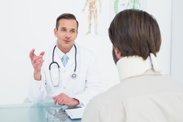 Male doctor in communication with patient at desk