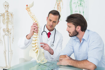 Male doctor explaining the spine to a patient
