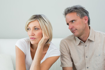 Displeased couple sitting on sofa after a fight