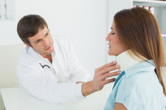 Doctor examining a patient's neck in medical office