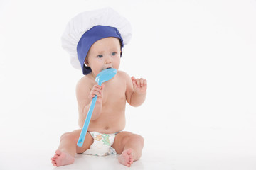 Cute little baby in toque with ladle