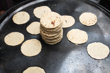 Cuisson de tortillas sur une plaque dans un marché