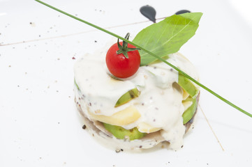 Herring salad with avocado sauce on a plate in a restaurant