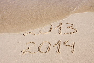 Year 2014 written in sand on tropical beach . 