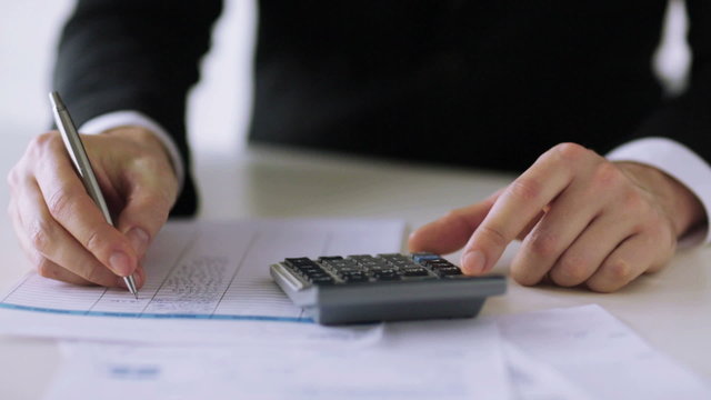 man with calculator filling a form