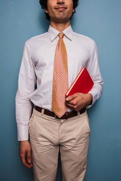 Young man in tie with a red book