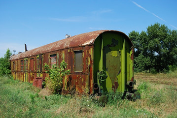 Abandoned rusty grunge railway wagon in sunny day