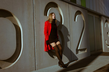 Beautiful girl posing with red coat