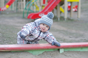 Fototapeta na wymiar baby playing with sand on playground