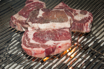 Ribeye steaks on a barbecue