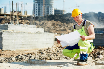 Engineer builders at construction site with draft