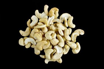 A stack of cashew nuts on the black background