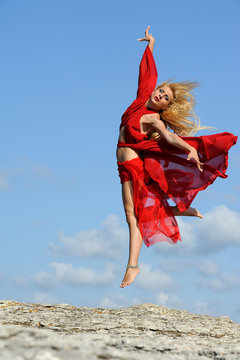 Woman in red dancing with clouds on air