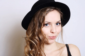 funny fashion woman with curls and blue eyes in hat. studio