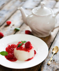 Delicious italian dessert panna cotta with raspberry sauce and m