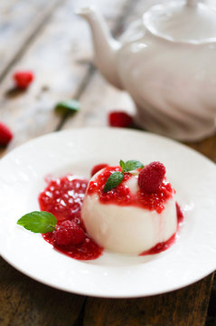 Delicious italian dessert panna cotta with raspberry sauce and m