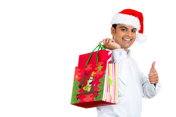 Happy christmas man holding gift bag, giving thumbs up