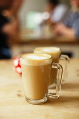 coffee latte in two tall glasses and sugar bowl, shallow dof