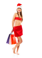 Beautiful Santa christmas girl with shopping bags on white