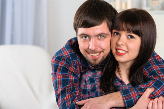 Portrait of young smiling couple at home