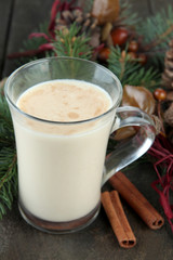 Cup of eggnog with fir branches and Christmas decorations