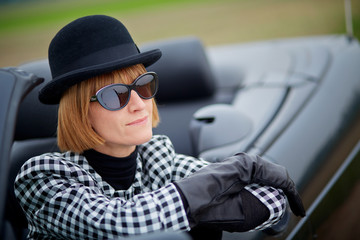 40s woman with sunglasses in a cabriolet