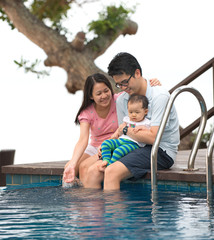 Fototapeta na wymiar Happy Asian Family Playing in the pool