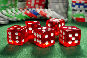 Red dice and chips on a green felt