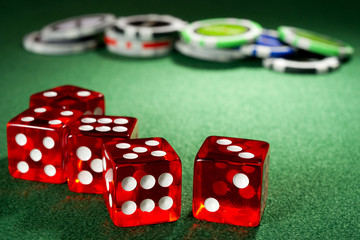 Red dice and chips on a green felt