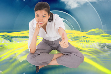 Composite image of businesswoman sitting cross legged showing th