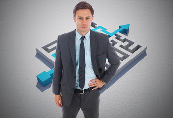 Composite image of serious businessman standing with hand on hip