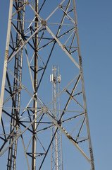 Steel telecommunication tower with antennas over blue sky 