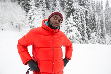 Fototapeta na wymiar African American Cheerful black man in ski suit in snowy winter