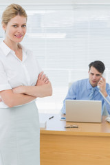 Obraz premium Smiling businesswoman with man working behind at office