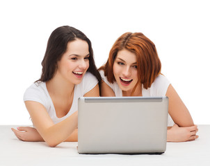 two smiling teenage girsl with laptop computer