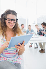 Woman using digital tablet with colleagues in background