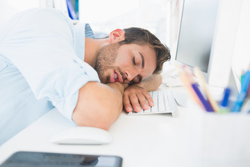Fototapeta premium Male artist with head resting on keyboard