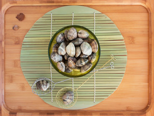 Clams in a bowl on a bamboo background