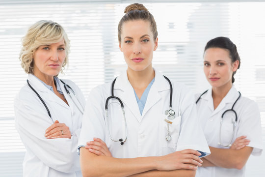 Three confident female doctors with arms crossed