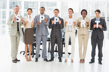 Obraz premium Happy business team holding up letters spelling support