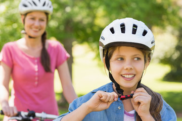 Fototapeta na wymiar Smiling woman with her daughter riding a bicycle