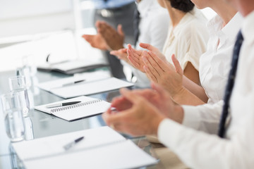 Business people clapping at a meeting