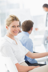 Obraz premium Blonde businesswoman smiling at camera during a meeting