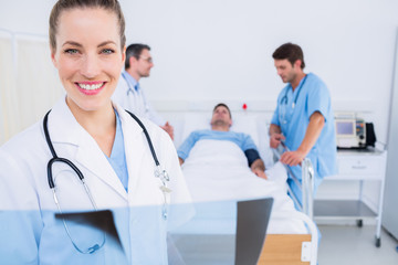 Doctor holding x-ray with surgeons and patient in hospital